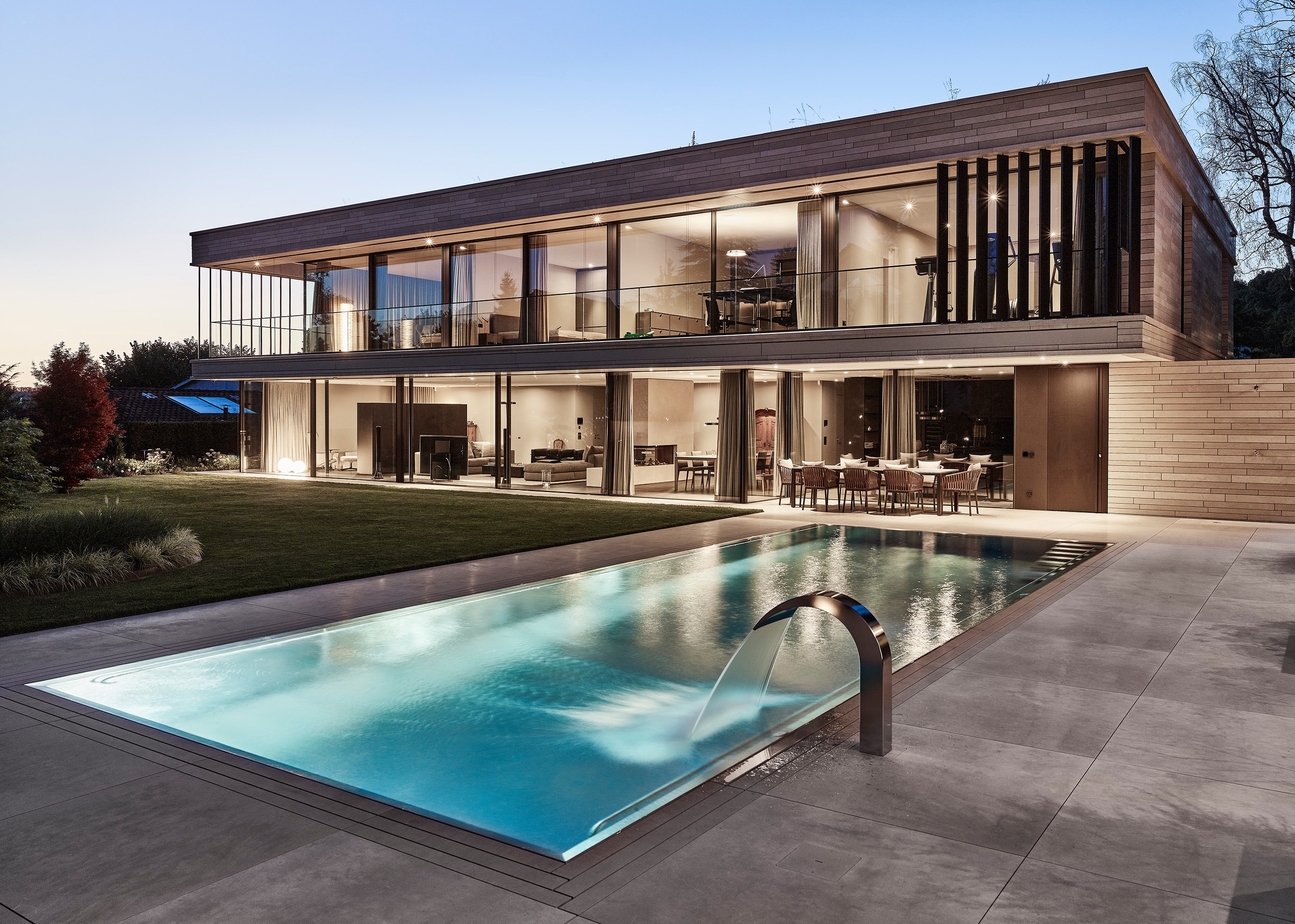 Wohnhaus in der Dämmerung mit Pool und offener Fassade