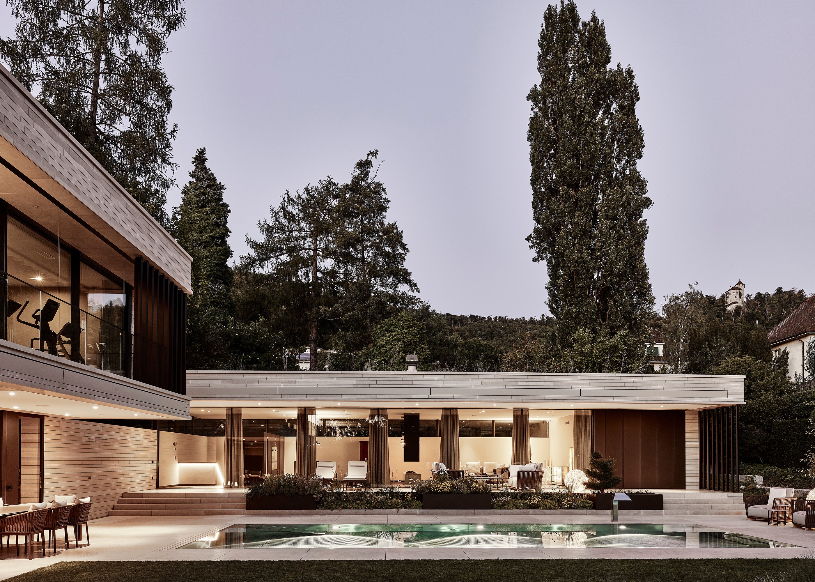 Wohnhaus am Abend, Blick über den Pool zum Wohngeschoss